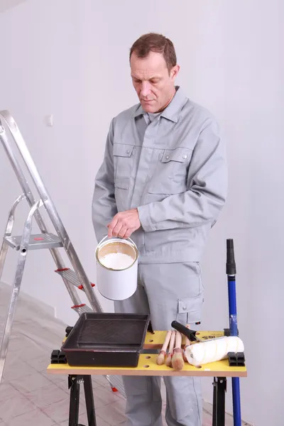 45 years old house painter is putting paint in a box