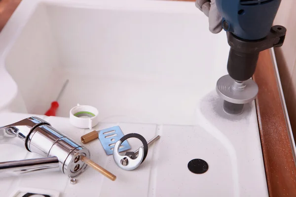 A sink and plumbing pieces and tools