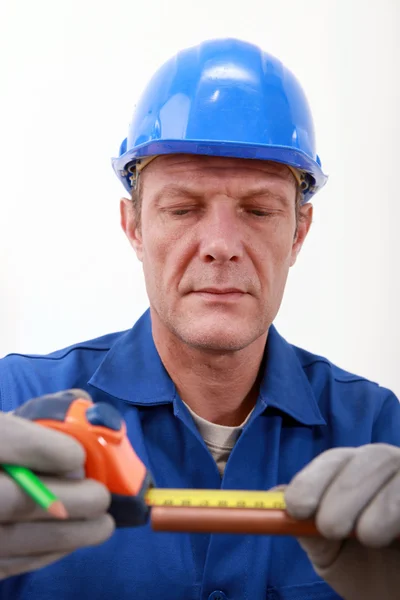 Worker measuring a copper tube