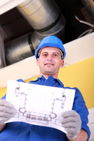 Plumber with the schematics of an air conditioning system