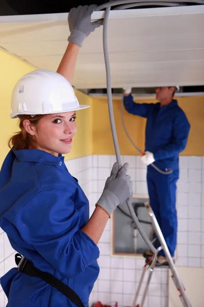 Female plumber apprentice and tutor at work