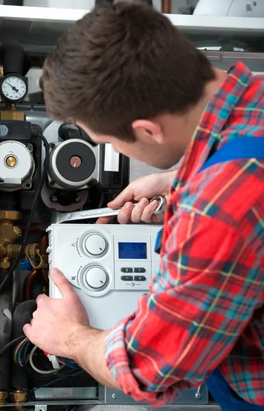 Technician servicing heating boiler