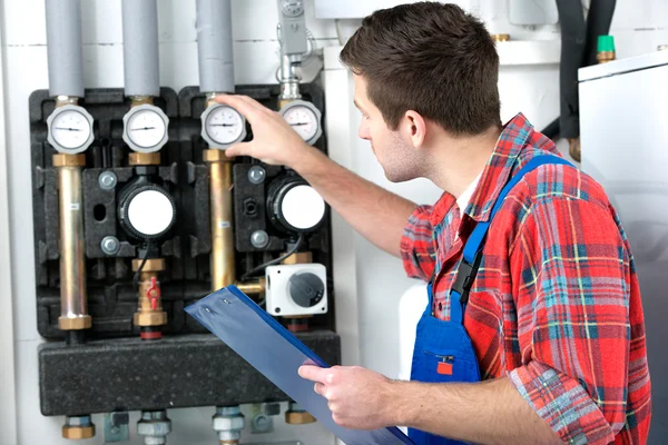 Technician servicing heating boiler