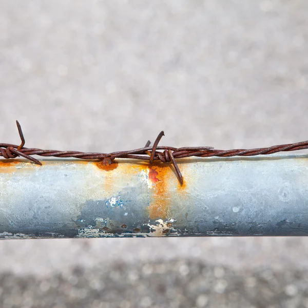 Rusty barbed wire on a metal tube