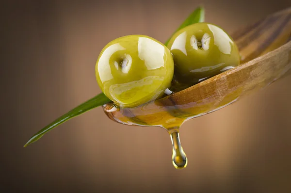 Olives with drop oil on wood spoon