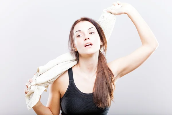 Tired woman after fitness exercise wiping with towel