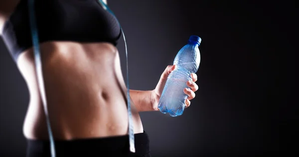 Woman after training holding water bottle