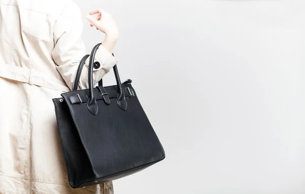 Fashionable woman with black bag, back view