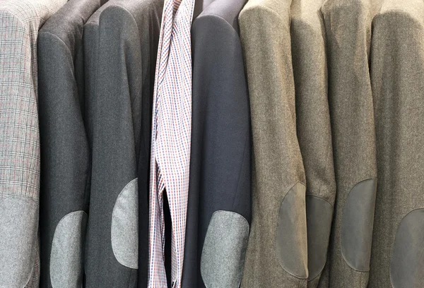 Row of suits jacket on hangers, apparel store