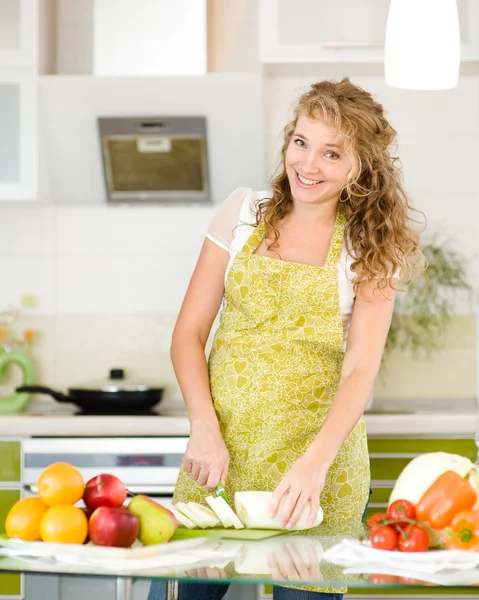Portrait of a smiling pregnant woman cooking in her kitchen