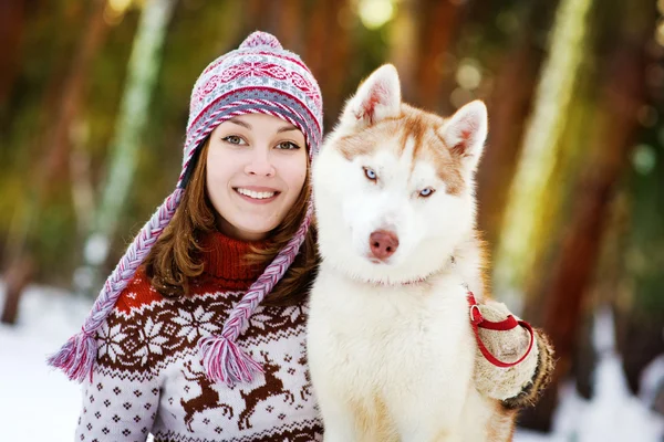 Closeup teen girl embracing cute dog in winter park