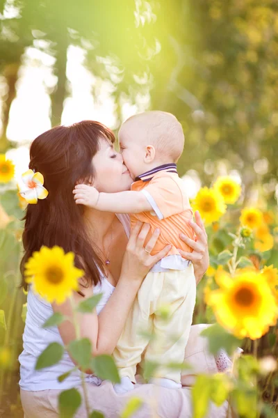 Happy family in spring field of beautiful sunflowers