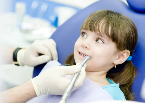 Little girl with open mouth during drilling treatment at the dentist