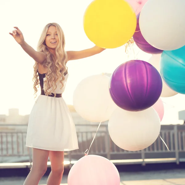 happy young woman with colorful latex balloons