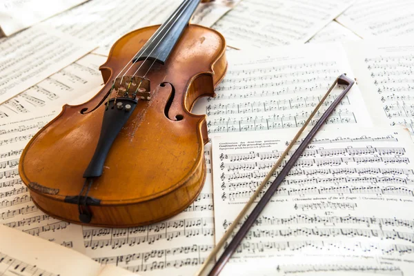 Old violin lying on the sheet of music