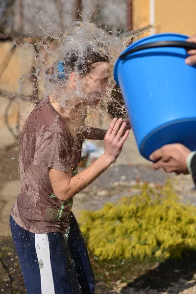 Man pours water on a girl out of the bucket