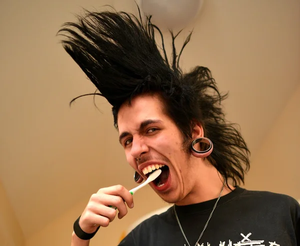 Punk boy brushes his teeth