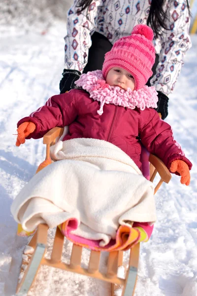 Mother and daughter sledging, nice winter scene
