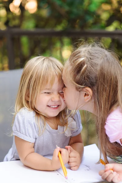 Two little sister kissing
