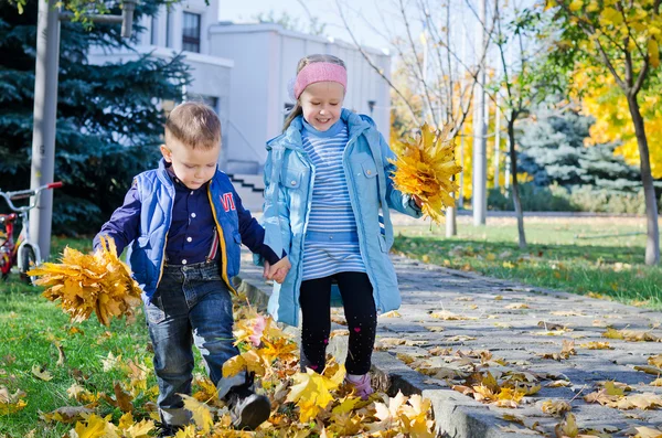 Children kicking autumn leaves