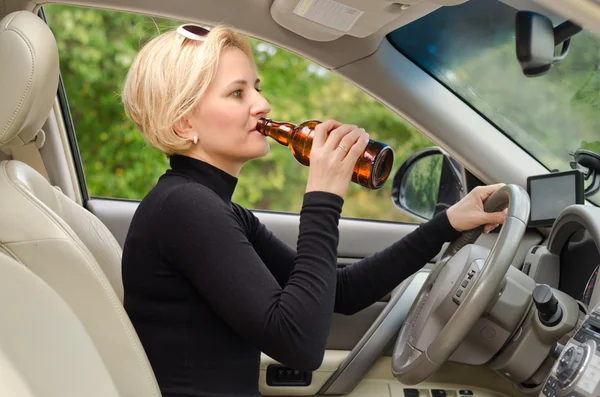 Young female driver drinking and driving