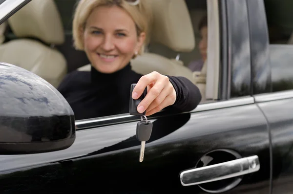 Woman driver showing off the keys of a new car