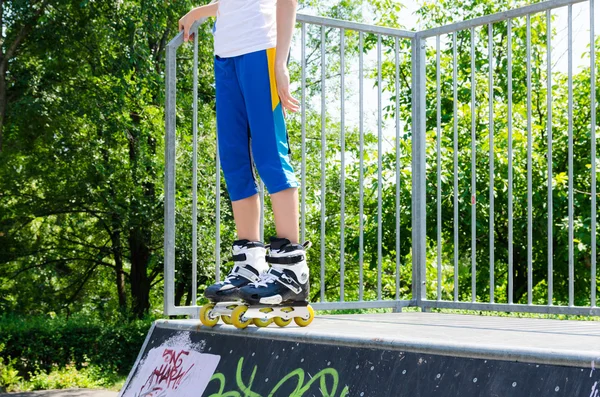 Legs of a young roller skater on a cement ramp