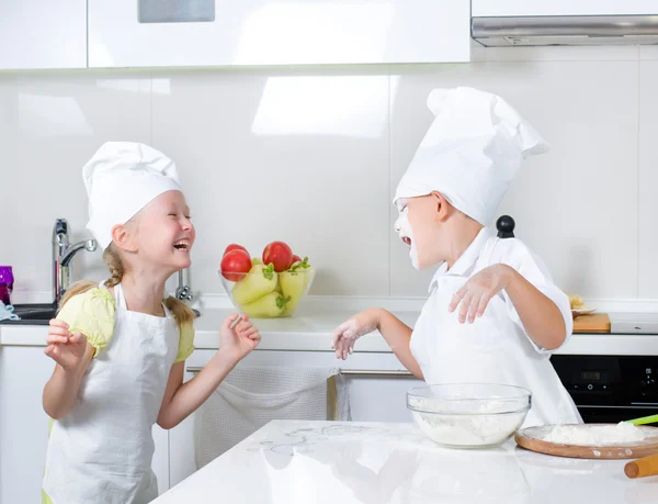 Happy little boy and girl baking in the kitchen