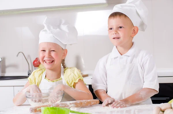 Happy little boy and girl cooking in the kitchen