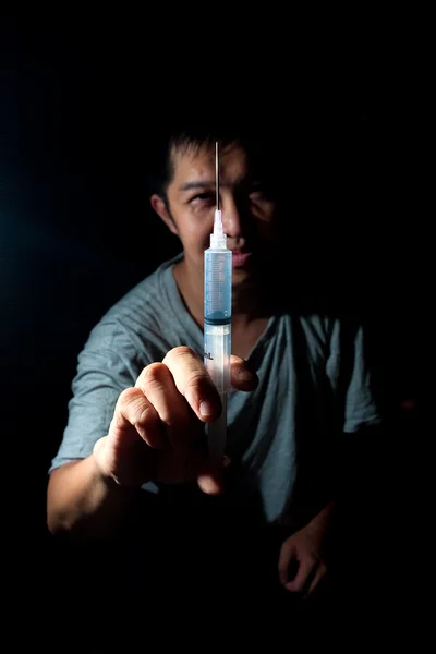 Drug addict showing off a syringe