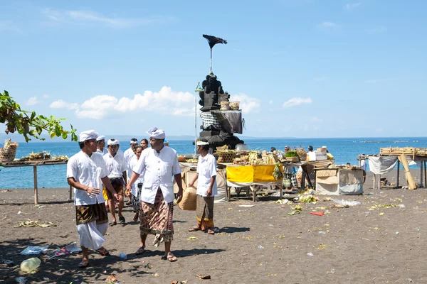 Villagers and devotees walking to the beach to give offerings to the spirits of the sea