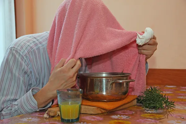 Man with pink towel breathe balsam vapors to treat colds and the