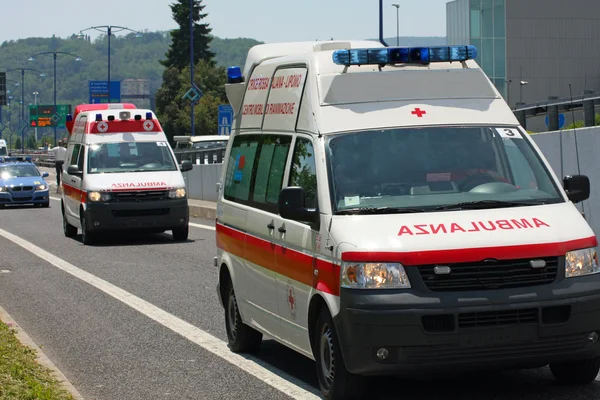 Two Italian Red Cross ambulance and a police car run fast in the