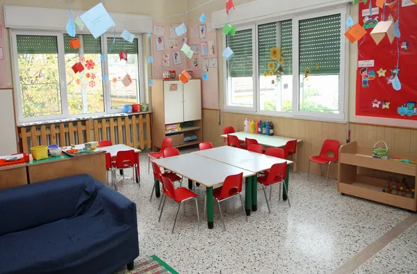 In a class of a nursery with drawings of children hanging on the