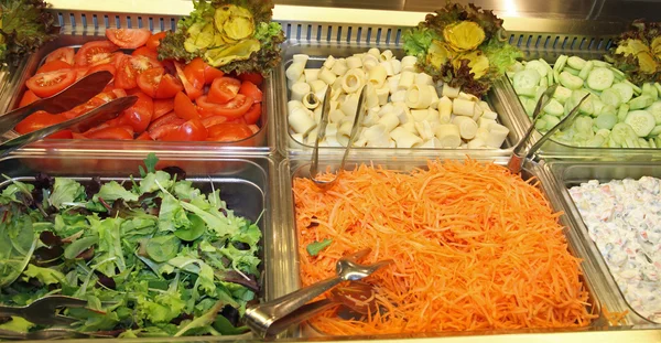 Steel trays with fresh vegetables in a self-service restaurant 1