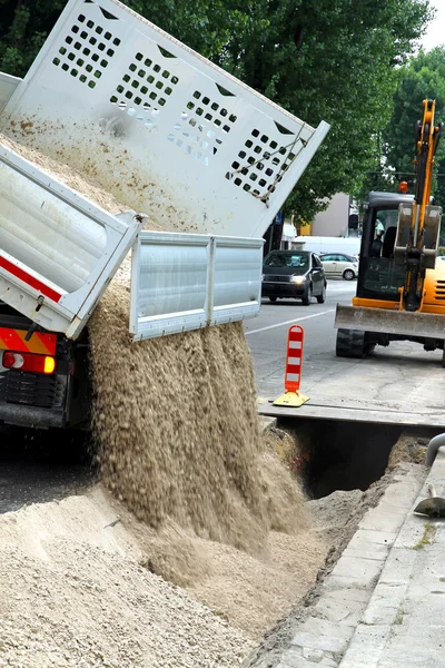 Truck tipper during the emptying of the gravel road during the e