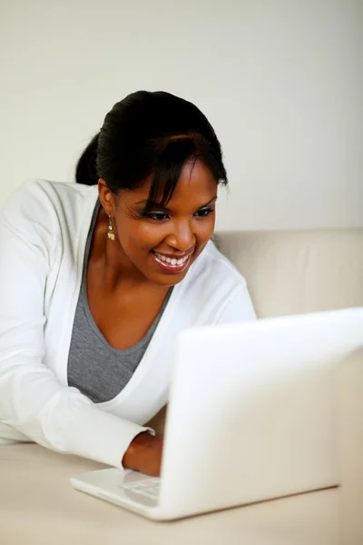 Smiling black woman looking on laptop screen
