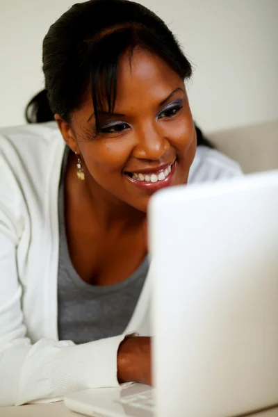 Smiling black female looking on laptop screen