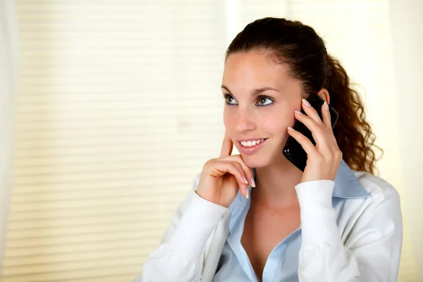 Smiling caucasian woman conversing on cellphone