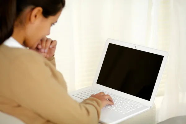 Charming young woman reading on laptop screen