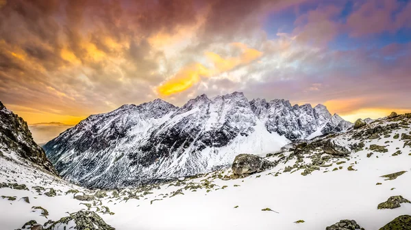 Panoramic view of white winter mountains after colorful sunset
