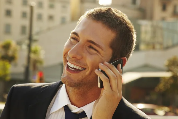 Happy young businessman calling with mobile phone