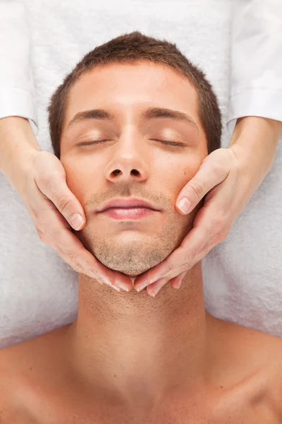 Young man receiving facial massage
