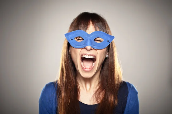 Portrait of a normal girl screaming with a blue mask