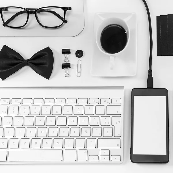 Closeup of business objects in order on white desk.