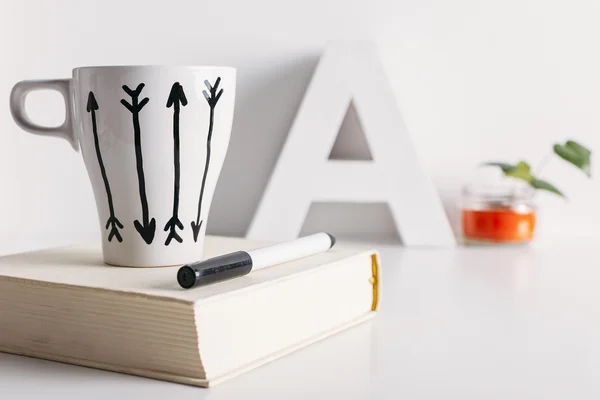 White coffee mug with arrows and diy decoration.