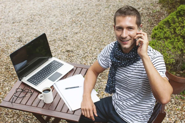 Young man working talking with smart phone in outdoors.
