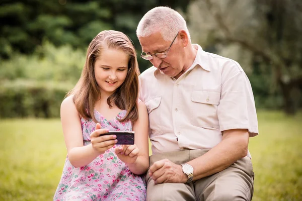 Grandchild shows grandfather smartphone