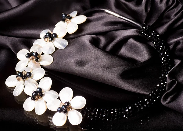 A bead necklace with flowers on black background