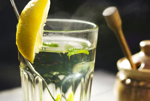 Close up of a glass of tea with a fresh peppermint